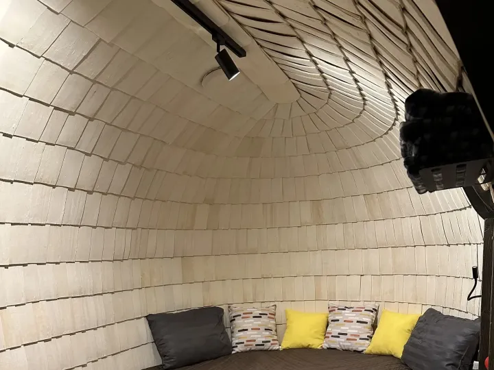 Curved shingle-lined room with upholstered seating