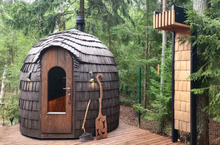 HobbitHut wood-shingle sauna with an arched entrance among trees